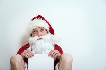 Naklejka premium Jobless half naked Santa sit with blank table and looks like beggar