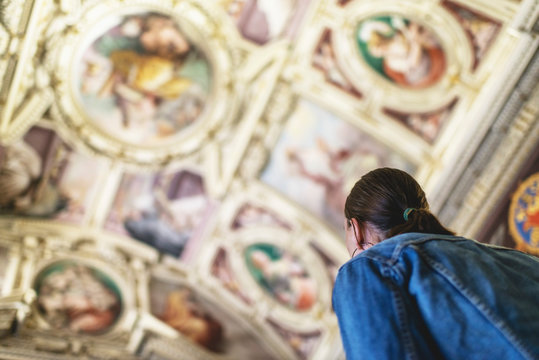 Female brunette tourist looking at ceiling of church in the Vati