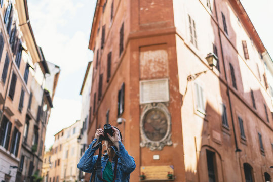 Female brunette tourist photographing streets of an italian city