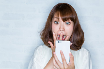 スマートフォン　/ 驚く女性