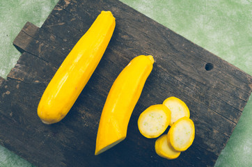 fresh ripe zucchinis lying on wooden board, one of them half