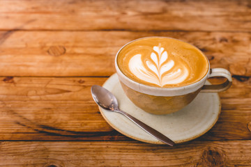 Hot art Latte Coffee in a cup on wooden table.