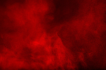 Red powder cloud against dark background