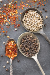 Black pepper corn, white pepper corn an dried chili flakes in ol