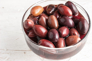 Obraz premium Kalamata olives on the glass bowl on the old wooden table