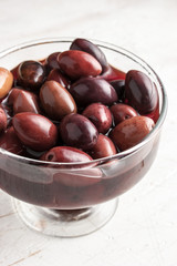 Kalamata olives in   brine on the glass dish vertical