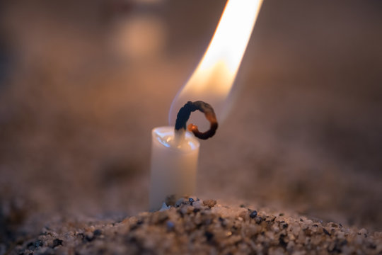 Brennende Kerze im Sand