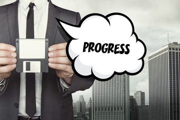 Progress text on speech bubble with businessman holding diskette