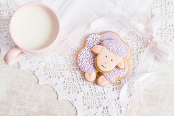 Fototapeta na wymiar Lavender gingerbread sheep with cup of milk on lace tablecloth.