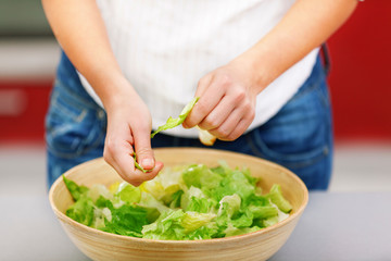 Young woman making salad