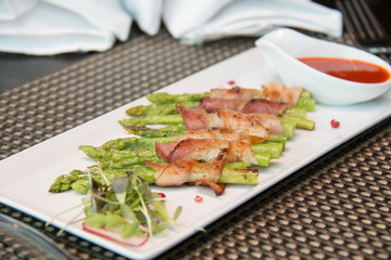 Asparagus wrapped in bacon with italian sauce