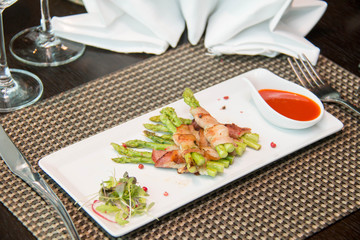 Asparagus wrapped in bacon with italian sauce