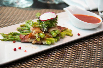 Asparagus wrapped in bacon with italian sauce