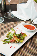 Asparagus wrapped in bacon with italian sauce