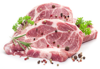 Raw pork meat steaks with spices on the white background.