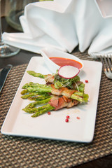 Asparagus wrapped in bacon with italian sauce