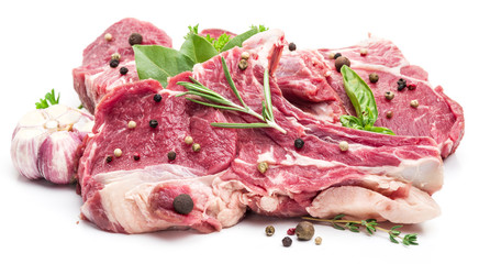 Raw pork meat steaks with spices on the white background.