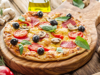 Pizza with mushrooms, salami and tomatoes.