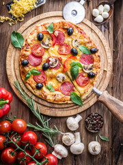 Pizza with mushrooms, salami and tomatoes.