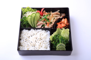 Buta Shoga Bento, stir fried  pork with sauce with rice and seaweed salad in bento isolated on white background.