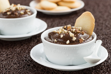 chocolate mousse with biscuits in white cups