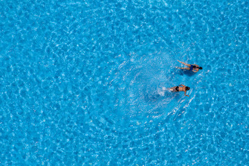 Aerial view of a two girls swimming in the pool
