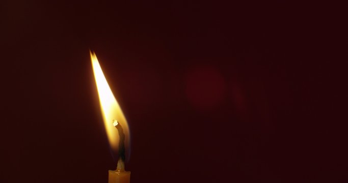 Macro close-up of candle on deep red background