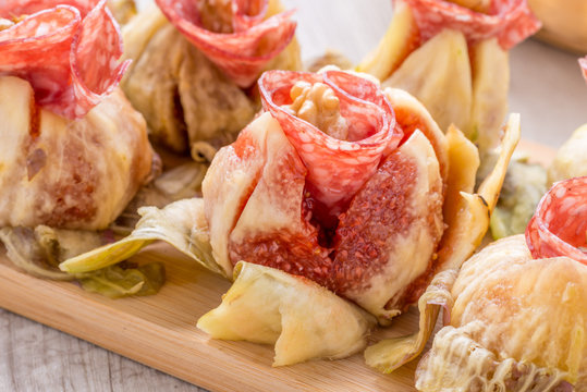 Fichi con roselline di salame e noci sul tagliere
