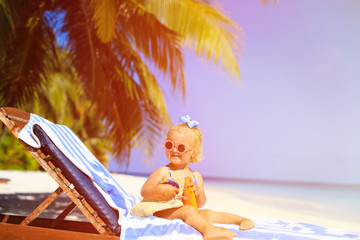Obraz na płótnie Canvas cute little girl with sunblock cream at the beach