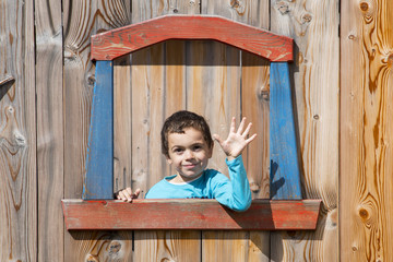 Bambini affacciati a un finestra di una casa di legno © alepvfoto