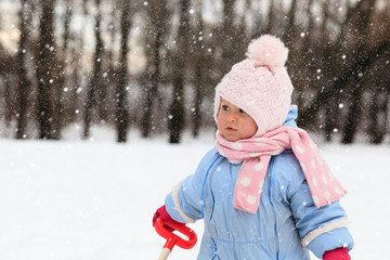 cute toddler girl having fun in winter snow