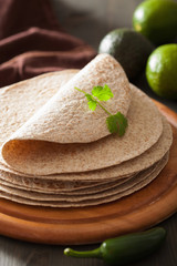 whole wheat tortillas on wooden board and vegetables