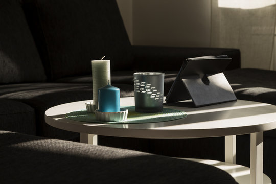 A group of candles and a tablet on a table