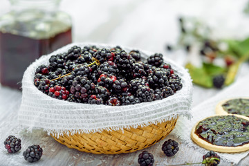 Fototapeta na wymiar Fresh blackberries bowl and jam sandwich biscuits on table