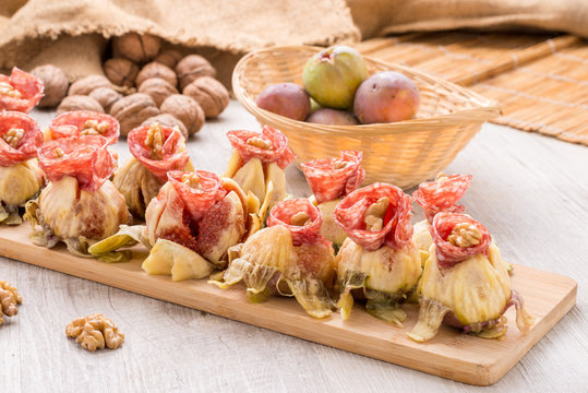 Fichi con roselline di salame e noci sul tagliere