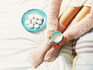 Woman relaxing at cozy home atmosphere on the bed. Young woman w