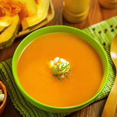 Delicious pumpkin soup on table