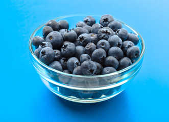 ripe blueberries in bowl isolated on cyan