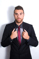 Young man dressed posing as a model. Shadow in the wall