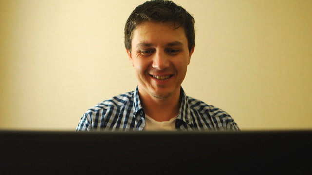 Man working on a notebook and smiling
