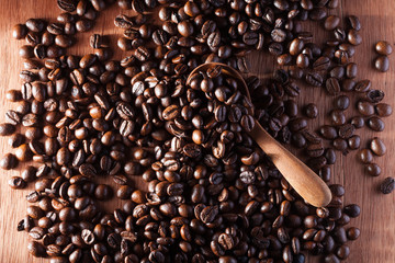 Coffee beans in wooden spoon close up