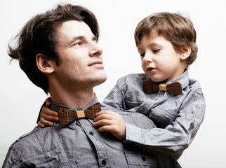 father with son in bowties on white background, casual look