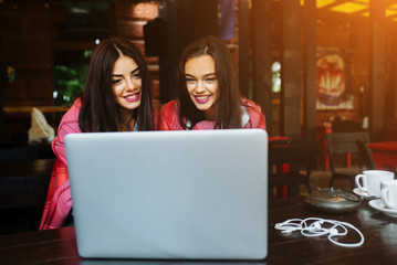 Obraz na płótnie Canvas two girls watching something in laptop