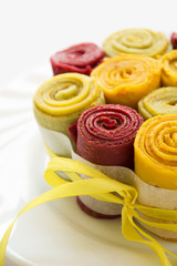 Colorful rolls from pancakes on white plate