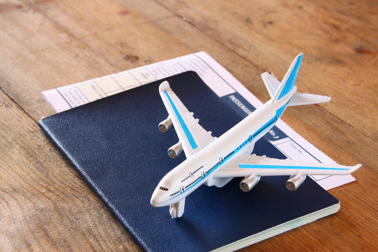 toy airplane and passport over wooden table. retro style image

