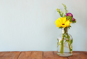 summer bouquet of flowers on the wooden table with mint background