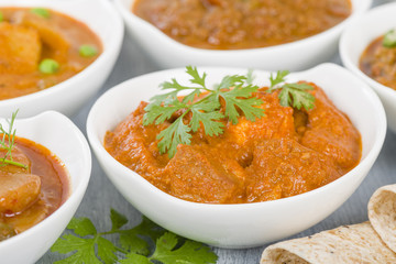 Paneer Makhani - Indian cheese cooked in a creamy sauce. Chapattis and other vegetarian curries on background.

