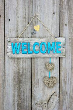 Welcome sign with hearts hanging on rustic wood door