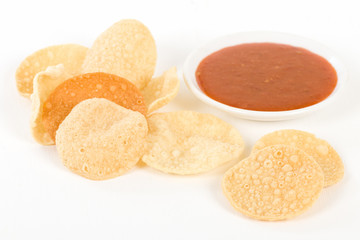 Poppadoms - Fried mini poppadoms on a white background. Served with chilli sauce.

