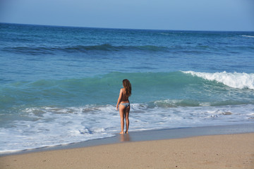 Fototapeta na wymiar mujer joven tomando el sol en la playa